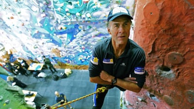 Fiennes, aged 62, scales a climbing wall during a press conference in East London, February 26, 2007. AFP