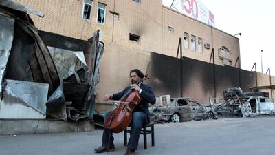 Karim Wasfi, former director for the Iraqi National Symphony Orchestra, plays on his cello next to debris in Baghdad's Sunni Adhamiya district, in a symbolic act of protest against violence. Sabah Arar / AFP