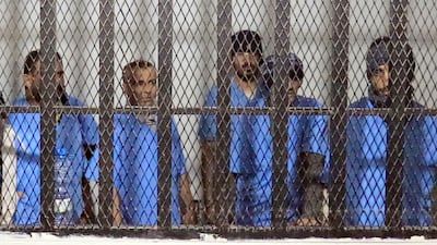 Defendants stand behind bars during sentencing at the state security court in Sanaa. EPA