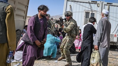 A US soldier points his gun at an Afghan passenger at Kabul airport on August 16, 2021, after the Taliban's swift takeover of the capital, as thousands of people attempt to flee the group's hardline Islamist rule. AFP