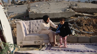 A mother and daughter outside their obliterated home in Jabalia, northern Gaza. The toddler was injured when a neighbouring house was targeted by Israeli bombers. AFP