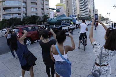 Passers-by take photos of the Trump Tank