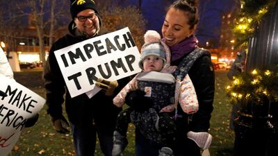 Jerry Crawford, left, of Dubuque, Iowa, and Nora Crawford and her daughter Nora, of Seattle, Wash., attend the "Nobody Is Above the Law" rally in Dubuque, Iowa. AP