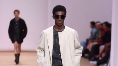 Several versions of lightweight coats graced the runway at the Prada spring/summer 2023 show, all worn with leather shorts and ankle-length cowboy boots. Photo: EPA