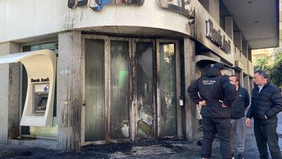 Protesters in Beirut set bank doors alight on Thursday. Nada Al Homsi / The National