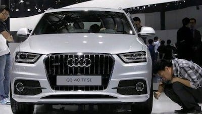 A visitor takes a photo of an Audi Q3 40 car with a Turbo Fuel Stratified Injection engine at Auto China 2012 in Beijing last week.