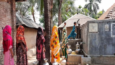 Women wait their turn to fill water at a collection point near their homes in Bangladesh