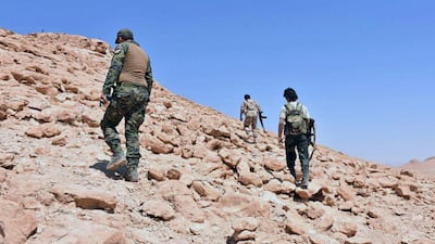 This photo, released on Sept 2, 2017 by the Syrian official news agency SANA, shows Syrian troops and pro-government gunmen advancing up a hill in the eastern city of Deir Ezzor, Syria. SANA via AP