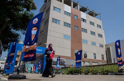 A woman walks in front of the Egyptian company VACSERA, where vials of China's Sinovac vaccine against the coronavirus are produced, in the capital Cairo, on September 1, 2021. AFP
