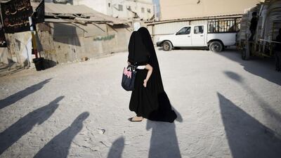 A Bahraini woman carries her child, in the village of Sanabis, west of Manama. Mohammed Al Shaikh / AFP