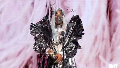 Lady Gaga, wearing a sculptural Candice Cuoco coat, Maisonmet mask and Valentino bodysuit, accepts the Tricon award during the MTV Video Music Awards. AP
