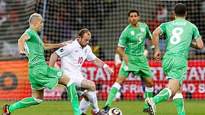 Wayne Rooney, centre, tries to find a way through the Algerian defence at Green Point Stadium in Cape Town.