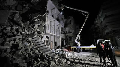 Members of the Syrian White Helmets search for victims after a building collapsed days after air strikes on the town of Ariha, in the south of Syria's Idlib province. AFP