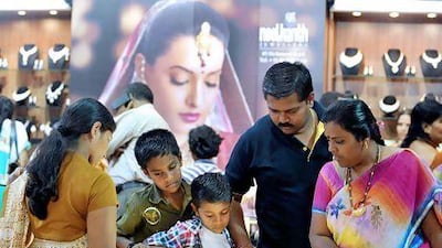 A family looks at a display of gold jewellery in Bangalore. India's government increased the import duty on gold to curb high demand. Manjunath Kiran / AFP
