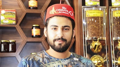 Syrian worker Husam Kiyat, who works at Syrian-owned Olabi Kahvesi, wears a fez embroidered with the phrase “We are Ottoman grandsons”. Many in the city of Mersin say they are is struggling to retain the traditional spirit of tolerance as the arrival of refugees from Syria has ballooned. Necdet Tas for The National
