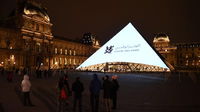 Images are projected onto the Louvre Pyramid in Paris on Wednesday to mark the opening of the Louvre Abu Dhabi on Saadiyat island in the UAE's capital. Eric Feferberg / AFP