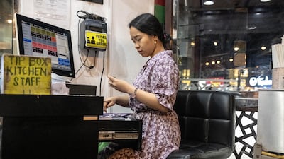 The cashier sits outside shouting orders to the kitchen