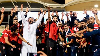 Bahrain's players and staff pose with the trophy during celebrations at Bahrain International Circuit in Sakhir. AFP