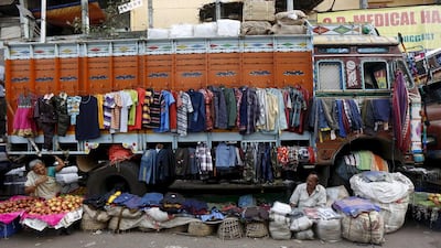Roadside vendors Sabitri Das, 59, and Narayan Prasad, 69, chat as they wait for customers in front of a parked truck. Das said that the city used to be less busy, which was good. Prasad said that people in the city are friendly and his sales have increased with the rising population.