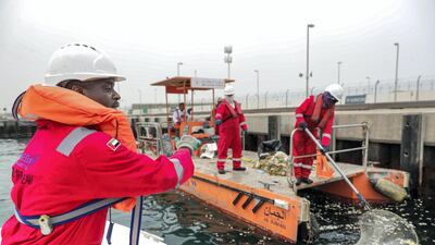 The team uses a special catamaran-type vessel to skim sea debris from the surface. Victor Besa / The National