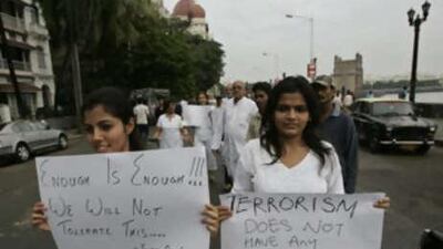 People carry placards as they participate in a demonstration near the landmark Taj Hotel in Mumbai, India, on Nov 30 2008.
