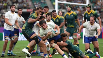 Manuel Diana of Uruguay gets tackled at the Oita Stadium. Getty