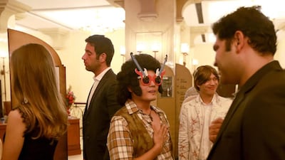 Kedy de Felix, centre, a waiter at Hoi An restaurant dressed as an 80's rock star to welcome guests at the New Year's Eve party in Shangri-La hotel, Abu Dhabi. Ravindranath K / The National