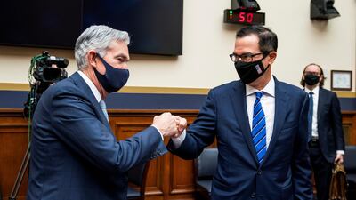 Federal Reserve Chairman Jerome Powell fist bumps Treasury Secretary Steven Mnuchin after a House Financial Services Committee hearing in the Rayburn House Office Building in Washington, US, December 2, 2020. REUTERS