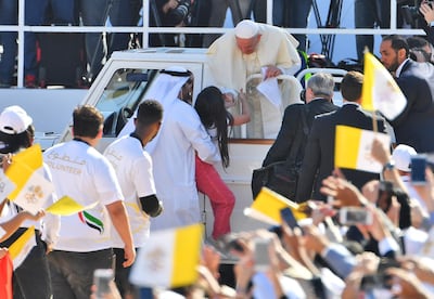 Pope Francis blesses a young girl as he arrives to lead mass for 180,000 Catholics in Abu Dhabi. AFP
