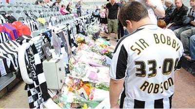 A Newcastle fan looks at the floral tributes to Sir Bobby Robson at St James' Park, Newcastle.