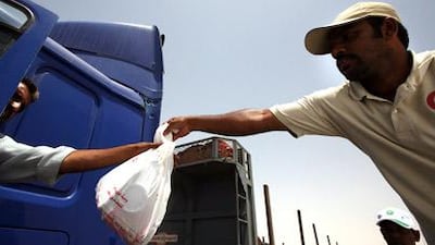 Aid workers pass out food to stranded truck drivers trying to pass through the Saudi UAE border.