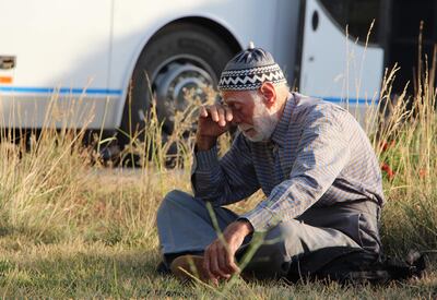 A Syrian man evacuated from the area of Fuaa and Kafraya in the Idlib province waits outside a bus during a security search by rebel forces. AFP