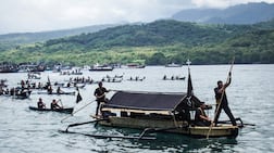 Catholic devotees transport a casket containing a statue of Jesus by boat during a Good Friday sea procession from Tuan Menino Chapel, a ritual inherited from Portuguese influence for over five centuries, in Larantuka, East Nusa Tenggara, on April 3, 2026. (Photo by ARNOLD WELIANTO / AFP)