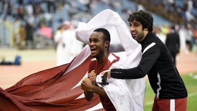Qatar's Khaled Maftouf, right, and Abdel Karim Fadlalla celebrate with the national flag after defeating Saudi Arabia 2-1 in the final of the 22nd Gulf Cup football match at the King Fahad stadium in Riyadh, on November 26, 2014. Fayez Nureldine / AFP