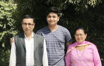 Nepali citizen Dibas Shrestha, centre, with his parents. He is among four UAE residents killed in Iranian attacks. Photo: Shrestha family