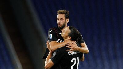 AC Milan's Hakan Calhanoglu, top, celebrates with his teammate Zlatan Ibrahimovic after scoring his side's opening goal at Lazio. AP