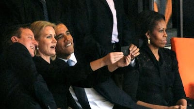 US President Barack Obama and British Prime Minister David Cameron pose for a selfie picture with Denmark's Prime Minister Helle Thorning Schmidt next to US First Lady Michelle Obama during the memorial service of South African former president Nelson Mandela at the FNB Stadium (Soccer City) in Johannesburg on December 10, 2013. AFP