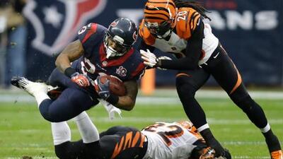 Houston Texans' Arian Foster is tackled by Reggie Nelson of the Cincinnati Bengals.