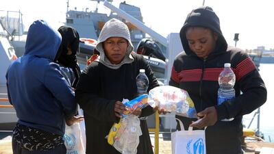 Rescued migrants receive food aid as they leave a coastguard vessel in Tripoli, Libya. AFP