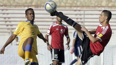 Libya's player Faisal al-Radri, right, controls the ball ahead of Rwanda's player Yannick Mukunzi during the FIFA World Cup 2018 qualifying football match between Libya and Rwanda on November 13, 2015, at the Sousse Olympic stadium. AFP PHOTO / SALAH LAHBIBI