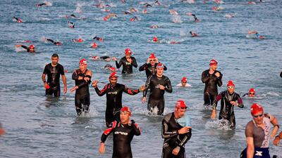 Competitors return to shore after completing the 1.9-km swim section of the Ironman 70.3 Dubai triathlon. AFP