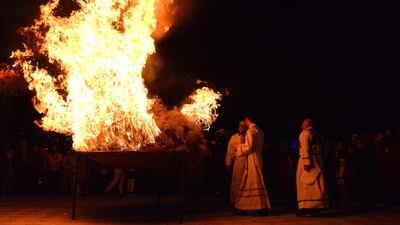 Priests burn a bonfire during a Christmas eve mass at the Saint Jacob Church in Mosul. AFP