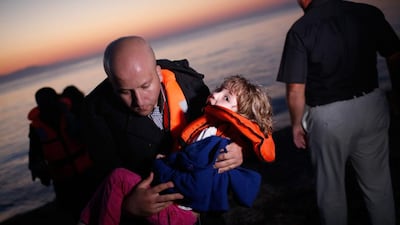 A migrant family from Syria arrives as the sun rises on the beach on the island of Kos after crossing a three mile stretch of the Aegean Sea from Turkey August 28, 2015 in Kos, Greece. Migrants from the Middle East and North Africa continue to flood into Europe at a rate that marks the largest migration since World War II. Win McNamee / Getty Images