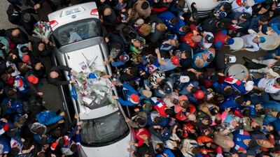 People surround the hearse carrying the remains of footballer Juan Izquierdo after a wake at his club Nacional in Montevideo, Uruguay. AP