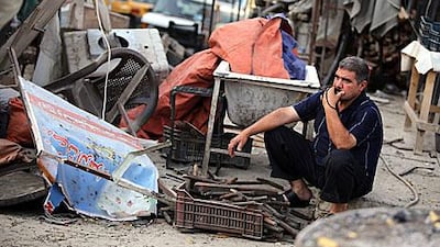 An Iraqi man sits amongst the debris at the site of a car bomb at a market in the Karrada district of Baghdad today.