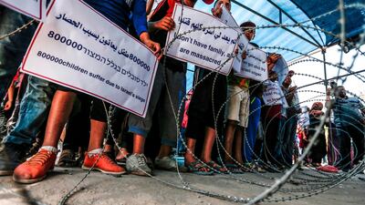Palestinian children demonstrate with signs at the Erez crossing with Israel near Beit Hanun in the northern Gaza Strip on July 24, 2018 against Israel's blockade on the enclave. AFP