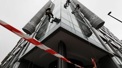 Workers clean the windows of the building which housed the offices of Cambridge Analytica in central London. Tolga Akmen / AFP