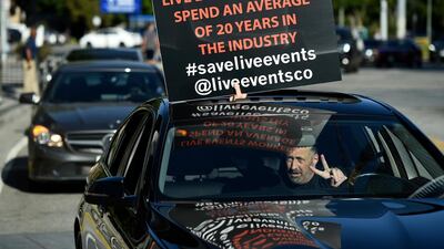 A live events professional takes part in the "Parade of Voices" caravan outside the ONE VOICE event, in honor of the live events industry which has been devastated by the Covid-19 pandemic at LA Live in Los Angeles, California, USA. AP Photo