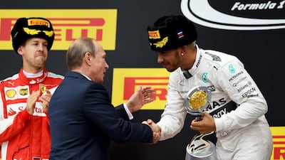 Lewis Hamilton, right, receives the trophy for winning the Russian Grand Prix from Russia president Vladimir Putin. Lars Baron / Getty Images