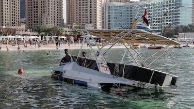 A sunken yacht being salvaged by its owner, Mohamed Irfan, and some volunteer divers off the beach on JBR. Antonie Robertson/The National